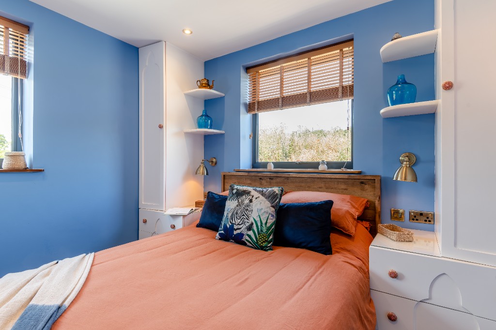 Moroccan-inspired bedroom with blue walls and built-in wardrobes