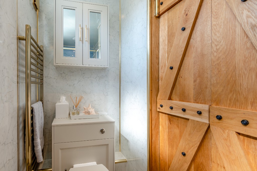 Bathroom with barn-style sliding door and marble finishes