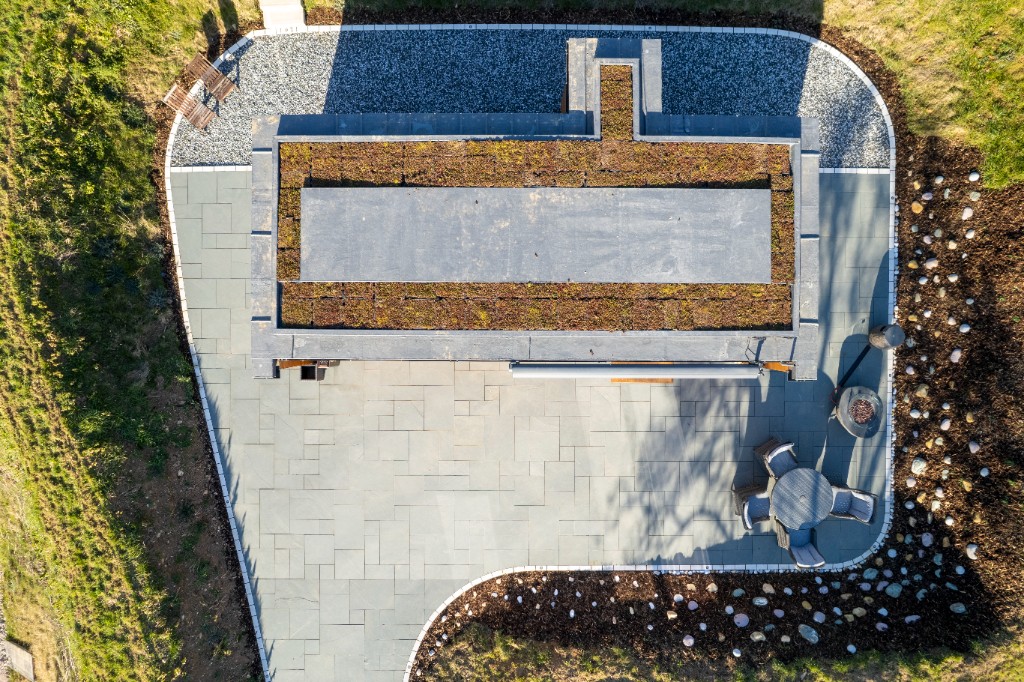Aerial view of an eco lodge with sedum green roof and patio at Enchanted Lodges